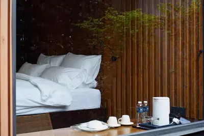 a view of a bed with white sheets and pillows at The Nhorm Hotel Ratchada in Bangkok
