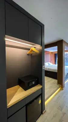 a room with a bedroom with a bed and a closet at The Nhorm Hotel Ratchada in Bangkok
