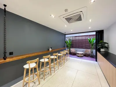a bar with a row of stools at The Nhorm Hotel Ratchada in Bangkok