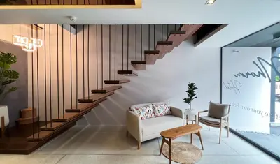 a living room with a staircase and a chair at The Nhorm Hotel Ratchada in Bangkok