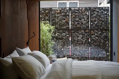 a bed with white pillows in front of a window at The Nhorm Hotel Ratchada in Bangkok