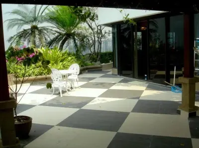 a patio with two white benches on a checkered floor at Stunning 24th Fl Terrace Penthouse! in Bangkok