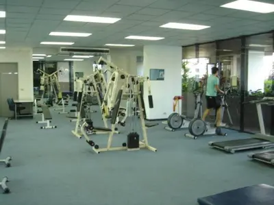 a gym with several tread machines and a man working out at Stunning 24th Fl Terrace Penthouse! in Bangkok