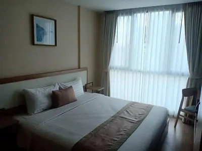 a bedroom with a large bed and a large window at Ramada Ekamai in Bangkok