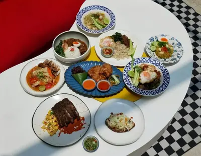a white table with plates of food on it at The Fig Lobby Bangkok in Bangkok