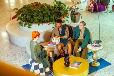 a group of three people sitting on a couch with a dog at The Fig Lobby Bangkok in Bangkok