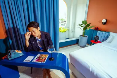 a woman sitting at a table in a hotel room at The Fig Lobby Bangkok in Bangkok