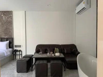 a room with a couch and a table and a bed at VEVILLA in Bangkok