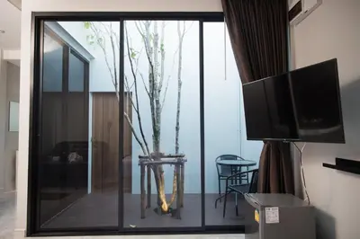 a living room with a sliding glass door with a tv at VEVILLA in Bangkok