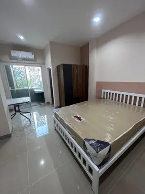a bedroom with a large bed in a room at Firstbuild Apartment (เฟิร์สบิวท์อพาร์ทเม้น) in Bangkok