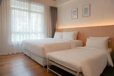 two beds in a hotel room with a window at Ago Hotel Chinatown in Bangkok