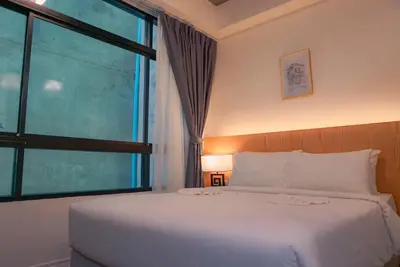 a bedroom with a bed and a large window at Ago Hotel Chinatown in Bangkok