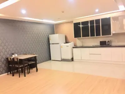 a kitchen with a table and a refrigerator at iCheck inn Residence Sukhumvit 1 in Bangkok