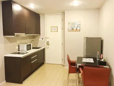 a kitchen with a table and a microwave at iCheck inn Residence Sukhumvit 1 in Bangkok