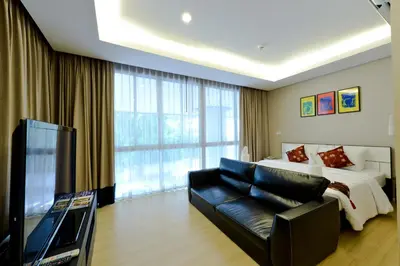 a bedroom with a bed and a couch and a tv at iCheck inn Residence Sukhumvit 1 in Bangkok