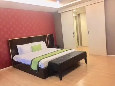 a bedroom with a bed with a red wall at iCheck inn Residence Sukhumvit 1 in Bangkok