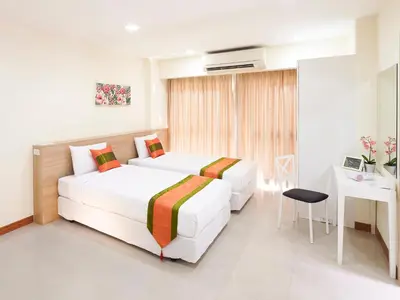 a hotel room with two beds and a desk at The Plimplace Hotel in Bang Su