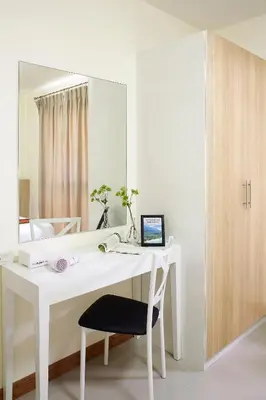 a white desk with a chair and a mirror at The Plimplace Hotel in Bang Su