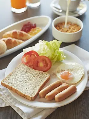 a plate of breakfast food with eggs sausage and toast at Bangkok City Suite in Bangkok