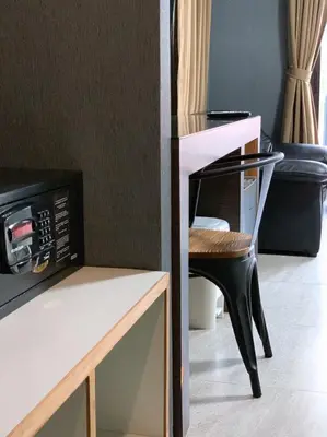 a table and a chair next to a microwave at Watana Hotel in Bangkok