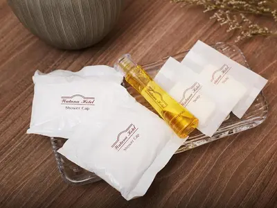 a bottle of oil and two bags on a table at Watana Hotel in Bangkok