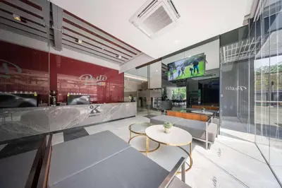a restaurant with a table and chairs and a tv at Ramada By Wyndham Bangkok Sukhumvit 87 in Bangkok