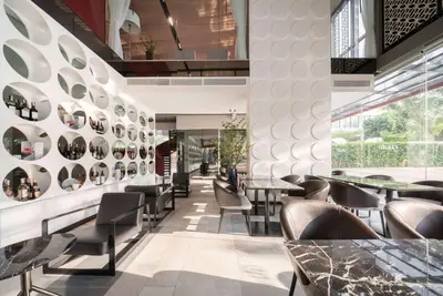 a restaurant with tables and chairs and a wall of plates at Ramada By Wyndham Bangkok Sukhumvit 87 in Bangkok