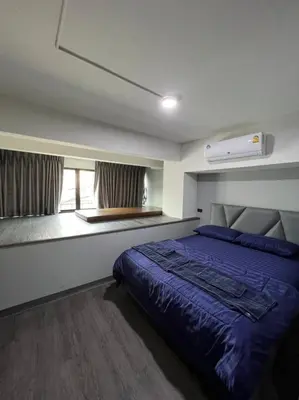 a bedroom with a blue bed and a window at W71 in Bangkok