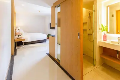 a bedroom with a bed and a bathroom with a sink at FX HOTEL NANA in Bangkok
