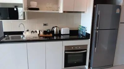 a kitchen with white cabinets and a stainless steel refrigerator at J Residence Thonglor 8 in Bangkok