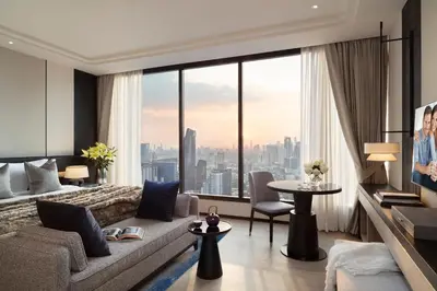 a living room with a couch and a large window at Ascott Thonglor Bangkok in Bangkok