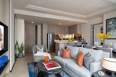 a living room with a couch and a kitchen at Ascott Thonglor Bangkok in Bangkok