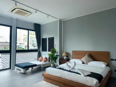 a bedroom with two beds and a balcony at Usman Halal Home in Bangkok