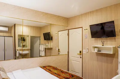 a bedroom with a mirror and a bed and a tv at Usman Halal Home in Bangkok