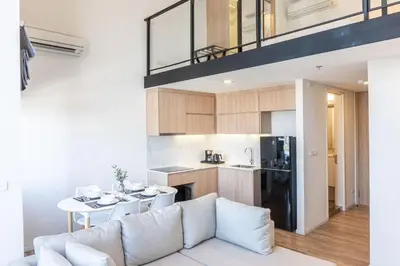 a living room and kitchen with a couch and a table at Ramada Plaza by Wyndham Bangkok Sukhumvit 48 in Bangkok