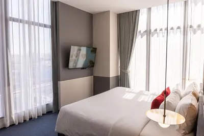 a hotel room with a bed and a large window at Ramada Plaza by Wyndham Bangkok Sukhumvit 48 in Bangkok