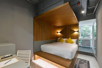 a bedroom with a large bed with a wooden headboard at Tiang Capsule in Bangkok