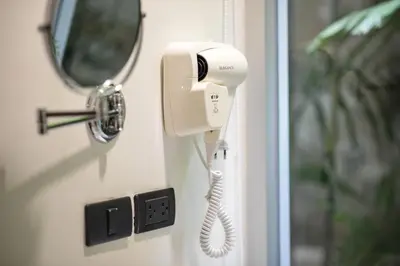 a phone attached to a door with a mirror at Tiang Capsule in Bangkok