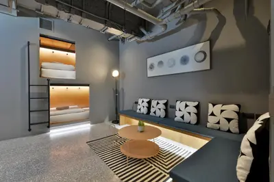 a room with a table and a bunk bed at Tiang Capsule in Bangkok