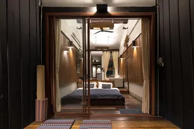 a room with a bed and a door leading to a bedroom at Humz Canal Stay in Nonthaburi