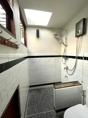 a bathroom with a shower and a toilet at Humz Canal Stay in Nonthaburi