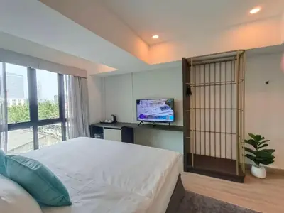 a bedroom with a large bed and a tv at VIVA LA VIDA HOTEL in Bangkok