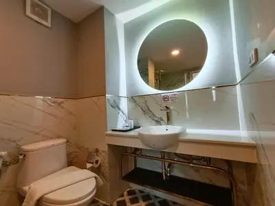 a bathroom with a sink and a toilet and a mirror at VIVA LA VIDA HOTEL in Bangkok