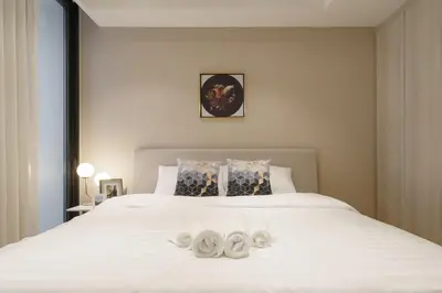 a bedroom with a white bed with two white shoes on it at Sukhumvit 11#Luxury#Pool#Gym#BTS Nana&MRT Sukhumvit#1BR#Max2ppl in Bangkok