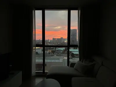 a living room with a window view of a city at Entire apartment near train station with pool & views in Ban Song Hong