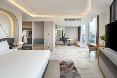 a hotel room with a bed and a desk at Asawin Grand Convention Hotel in Bangkok