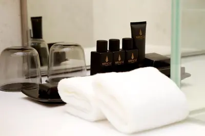a white towel sitting on top of a counter with wine glasses at Asawin Grand Convention Hotel in Bangkok