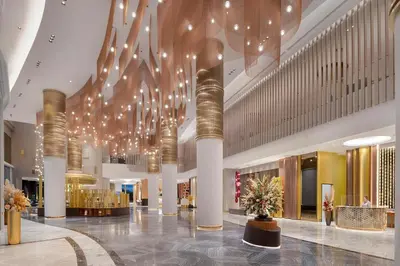 a lobby with chandeliers and lights in a building at Asawin Grand Convention Hotel in Bangkok