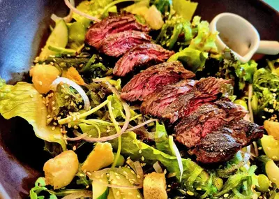 a salad with meat and vegetables in a bowl at Coconut Lane Bangkok in Bangkok