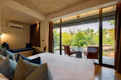 a bedroom with a bed and a large window at Coconut Lane Bangkok in Bangkok